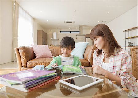 Mother and son studying in a living room Stock Photo - Premium Royalty-Free, Code: 670-06024684