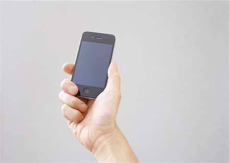 Hand holding a smartphone Stock Photo - Premium Royalty-Free, Code: 670-06450490
