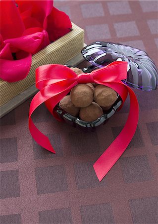 Petals and chocolates tied with ribbon Stock Photo - Premium Royalty-Free, Code: 670-06451017