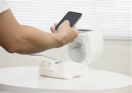 Hand mit einem Smartphone und einem automatischen Blutdruckmessgerät Stockbilder - Premium RF Lizenzfrei, Bildnummer: 670-06451206