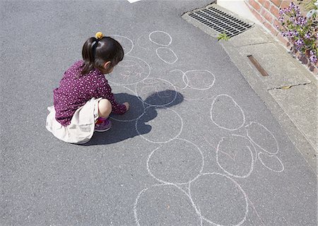 Girl drawing a picture with chalk Stock Photo - Premium Royalty-Free, Code: 670-06824797