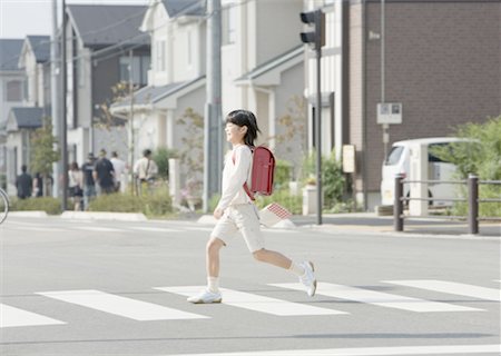 fußgängerüberweg - Ein Mädchen zu Fuß auf dem Fußgängerüberweg Stockbilder - Premium RF Lizenzfrei, Bildnummer: 670-02120405