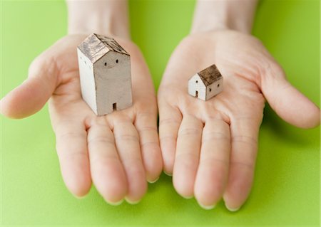 Gros plan des mains tenant des maisons miniatures Photographie de stock - Premium Libres de Droits, Code: 670-03607588