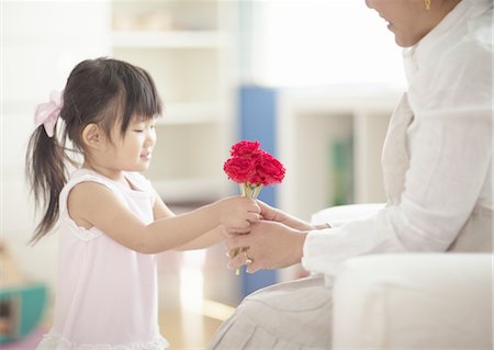 Girl giving carnation flowers to her mother Stock Photo - Premium Royalty-Free, Code: 670-03709848