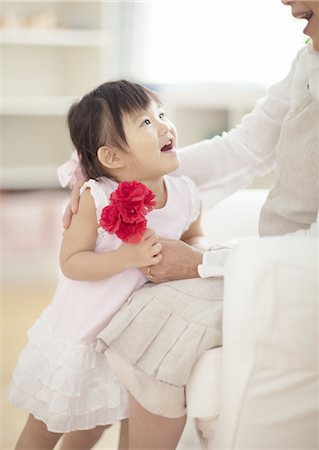 Girl and mother holding carnation flowers Stock Photo - Premium Royalty-Free, Code: 670-03709849