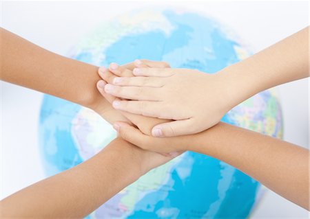 Overlapping hands and a globe Stock Photo - Premium Royalty-Free, Code: 670-03710169