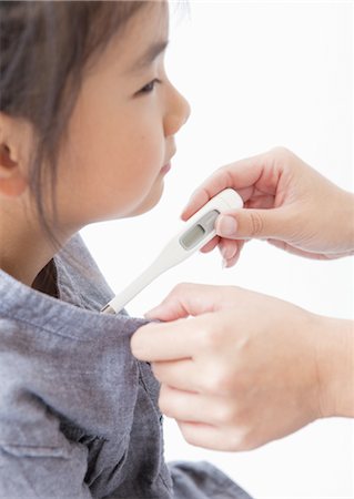 fever - A girl checking her temperature Stock Photo - Premium Royalty-Free, Code: 670-03710177
