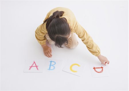 Girl lining up alphabet cards Foto de stock - Sin royalties Premium, Código: 670-03886070