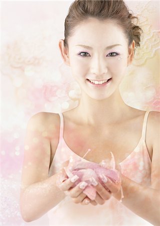 Young woman holding petals Stock Photo - Premium Royalty-Free, Code: 670-03887071