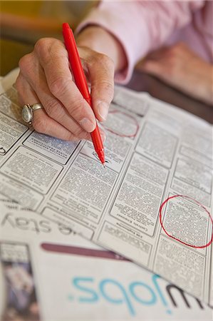 Woman circling employment ads in paper Stock Photo - Premium Royalty-Free, Code: 673-06025365