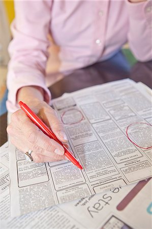 people looking at papers - Woman circling employment ads in paper Stock Photo - Premium Royalty-Free, Code: 673-06025367