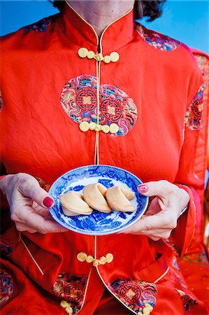 Woman holding plate of fortune cookies Foto de stock - Royalty Free Premium, Número: 673-06025386