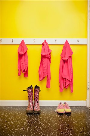 rain boots - Sweaters on hooks with boots and shoes below Stock Photo - Premium Royalty-Free, Code: 673-06025409