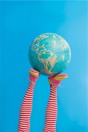 socks and shoes - Legs in striped socks with colorful shoes holding globe Stock Photo - Premium Royalty-Free, Code: 673-06025425