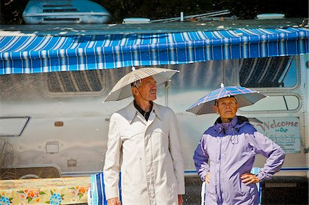downpour - Senior couple in rain hats near airstream camper Stock Photo - Premium Royalty-Free, Code: 673-06025484