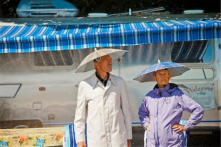 picture of elderly cheering - Senior couple in rain hats near airstream camper Stock Photo - Premium Royalty-Free, Code: 673-06025484