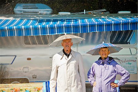 Senior couple in rain hats near airstream camper Foto de stock - Sin royalties Premium, Código: 673-06025485