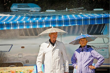 senior couple rv - Senior couple in rain hats near airstream camper Stock Photo - Premium Royalty-Free, Code: 673-06025483