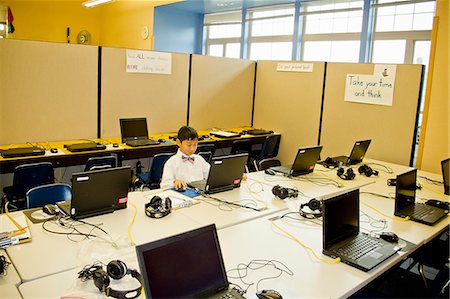 stanza dei computer - Young boy seated at school laptop in computer lab Fotografie stock - Premium Royalty-Free, Codice: 673-06025534