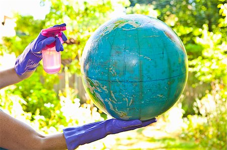 Woman wearing rubber gloves to clean globe outdoors Stock Photo - Premium Royalty-Free, Code: 673-06025569