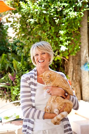 seniors outside friends - Woman holding orange cat on patio Foto de stock - Sin royalties Premium, Código: 673-06025718