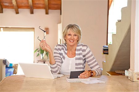 Woman working at home office with computer and bills Stock Photo - Premium Royalty-Free, Code: 673-06025729