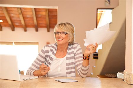 simsearch:673-03826402,k - Woman in home office holding bills Stock Photo - Premium Royalty-Free, Code: 673-06025736