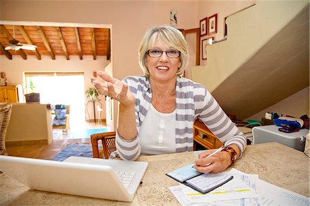 Femme travaillant à la maison bureau avec ordinateur et factures Photographie de stock - Premium Libres de Droits, Code: 673-06025733