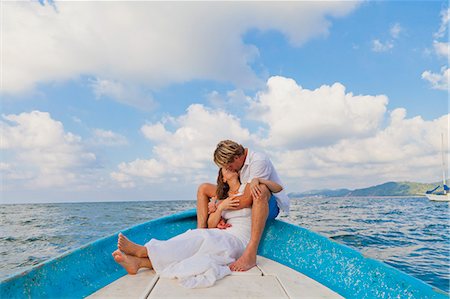 romantic lake side images - Man and woman embracing in bow of boat Stock Photo - Premium Royalty-Free, Code: 673-06964475