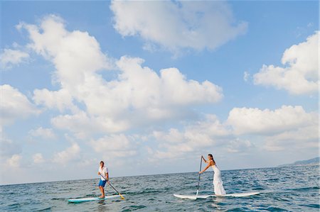 female surfers - Dressed up man and woman riding paddle boards Stock Photo - Premium Royalty-Free, Code: 673-06964470