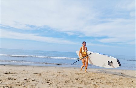 Woman on beach with paddle board Stock Photo - Premium Royalty-Free, Code: 673-06964483