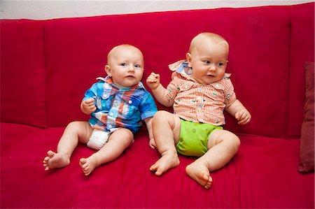 Two babies on red sofa Stock Photo - Premium Royalty-Free, Code: 673-06964575