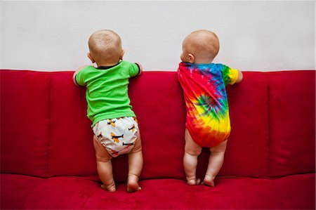 Two babies standing on red sofa Foto de stock - Sin royalties Premium, Código: 673-06964579