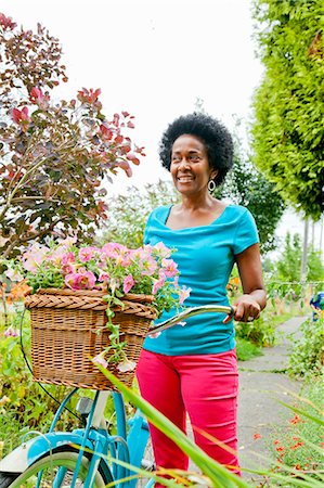 riding bike female basket - Woman riding retro bicycle with flower basket Stock Photo - Premium Royalty-Free, Code: 673-06964571