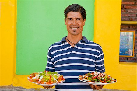 Man holding plates of mexican food Stock Photo - Premium Royalty-Free, Code: 673-06964604