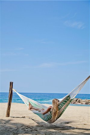 Young woman in hammock on beach Stock Photo - Premium Royalty-Free, Code: 673-06964659