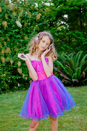 Teen girl in party dress listening to music outdoors Foto de stock - Sin royalties Premium, Código: 673-06964680