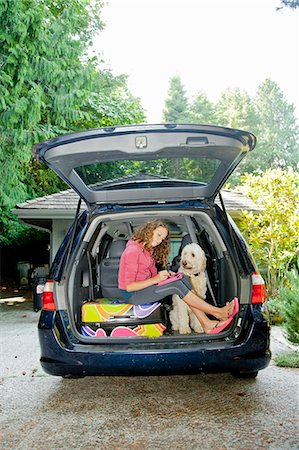 driveway low angle - Teen girl with luggage and dog in car Stock Photo - Premium Royalty-Free, Code: 673-06964691