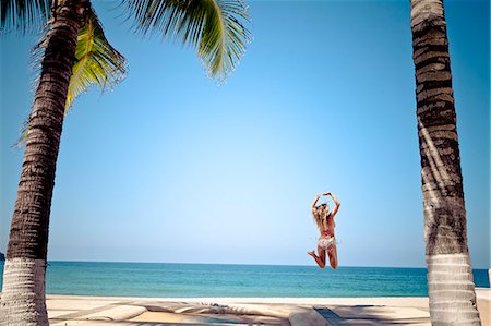 simsearch:673-06964714,k - Woman in bikini jumping on beach Foto de stock - Sin royalties Premium, Código: 673-06964732