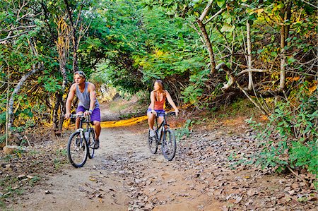 simsearch:673-06964473,k - Couple riding bicycles on jungle path Stock Photo - Premium Royalty-Free, Code: 673-06964791