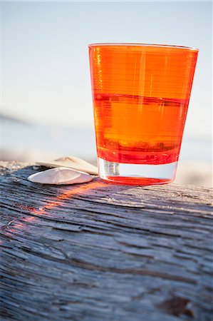 Orange cup on driftwood log Foto de stock - Royalty Free Premium, Número: 673-06964804