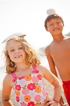 diversity kids on beach - Young boy and girl balancing shells on their heads Stock Photo - Premium Royalty-Free, Code: 673-06964811