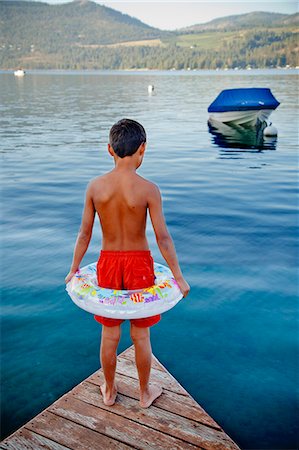 Young boy wearing float ring on dock Photographie de stock - Premium Libres de Droits, Code: 673-06964844