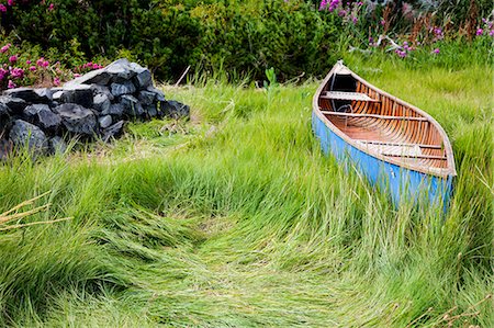 Blue canoe resting in tall grass Foto de stock - Sin royalties Premium, Código: 673-08139208