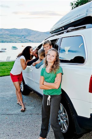 Woman kissing a man through a car window in front of their kids Stock Photo - Premium Royalty-Free, Code: 673-08139216