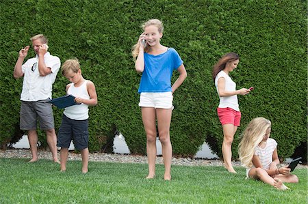 simsearch:6108-06166923,k - Family of five all using technology outdoors Stock Photo - Premium Royalty-Free, Code: 673-08139219