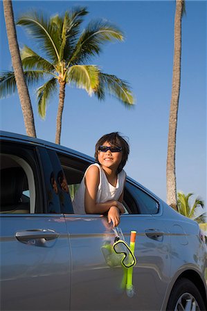 Boy holding a scuba mask and snorkel leans out a car window Stock Photo - Premium Royalty-Free, Code: 673-08139211