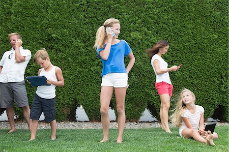 pda phone - Family of five all using technology outdoors Stock Photo - Premium Royalty-Free, Code: 673-08139220