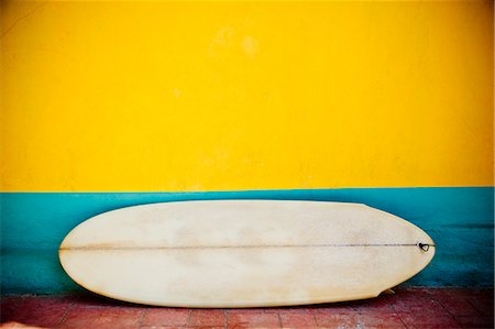 surf boards - Vintage surfboard against a colorful, striped wall Foto de stock - Sin royalties Premium, Código: 673-08139241