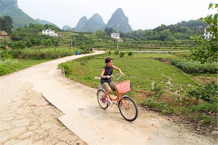 rural asia - Boy rides a bicycle in the Yangshuo countryside, Yangshuo, China Stock Photo - Premium Royalty-Free, Code: 673-08139285